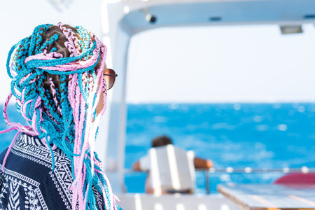 Person with colorful braids on boat.