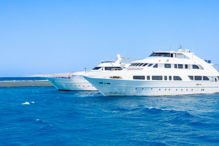 Luxury yachts sailing on open sea.