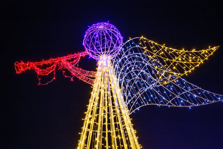 Illuminated angel sculpture with trumpet at night.の写真素材
