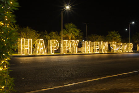 Illuminated happy New Year sign on street at night.の写真素材