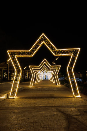 Illuminated star-shaped arches in nighttime outdoor setting.