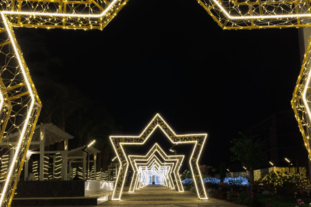 Illuminated star-shaped arches in night garden.の写真素材