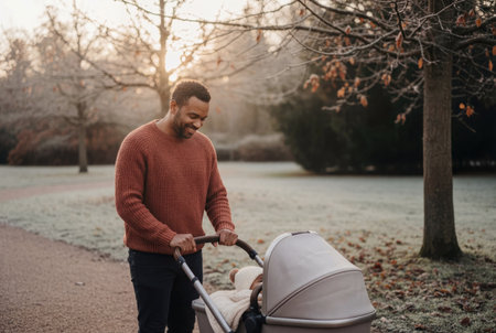 Happy father pushing baby in stroller on a frosty morning walk.の素材