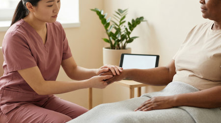 Nurse comforting senior patient during a home visit.の素材
