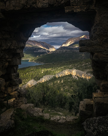 A beautiful landscape formed by mountains, forests, a lake, & a dramatic sky in Catalunya, spain