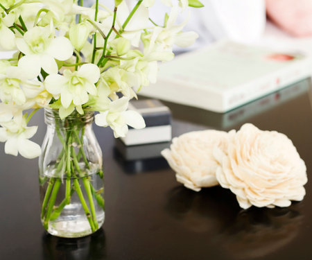 Orchids in glass vase on pretty bedside table close upの写真素材