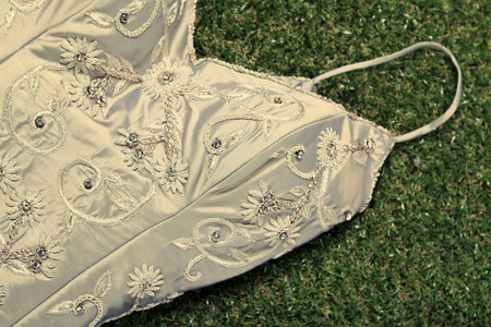 Close up details of a vintage gown on grass