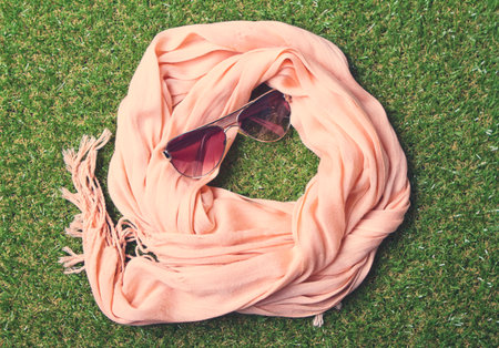Overhead view of fashion scarf and sunglasses on grassの写真素材