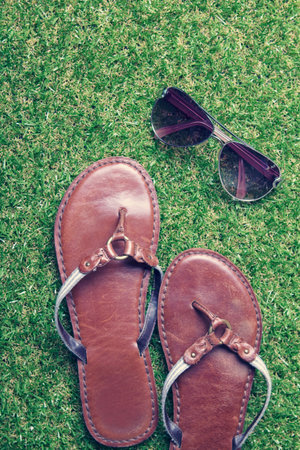 Close up of summer sandals and sunglasses on grassの写真素材