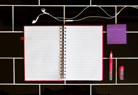 Open notepad headphones and stationery pink purple colorsの写真素材