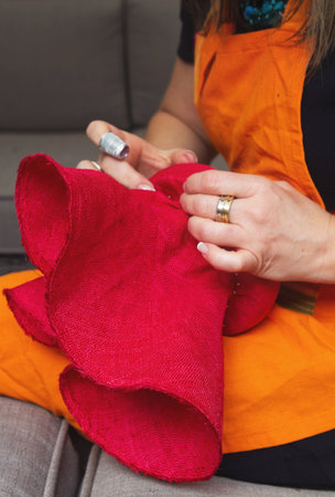 Milliner woman pinning a fashion hat fascinatorの写真素材