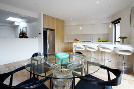 Kitchen with island bench and open plan dining area in modern australian homeの写真素材