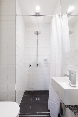 Small renovated white ensuite bathroom with rain showerの写真素材