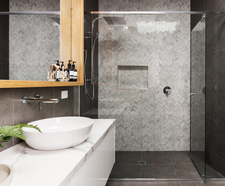 Marble mosaic herringbone tiled shower feature wall in a contemporary ensuite bathroomの写真素材