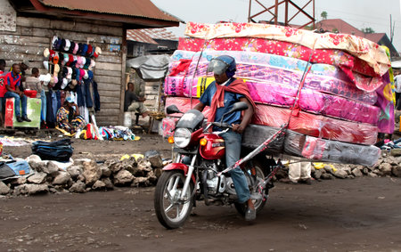 In Goma, Democratic Republic of Congo, people often carry huge loads on their motorcycles.の写真素材