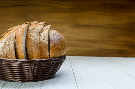 A Sliced Pain De Campagne Au Levain Bread in the wicker brown wood basket bowl.