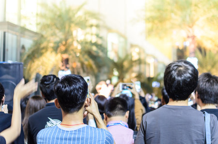 A lot of people has shooting and recording to a singer in mini concert at night.のeditorial素材