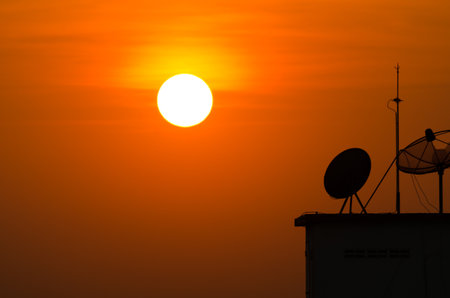 satellite dishes over sunsetの写真素材