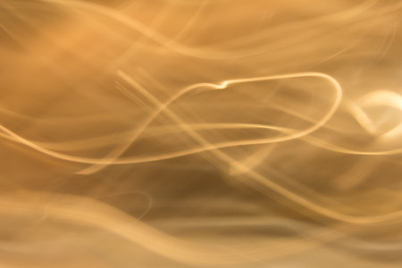 Abstract movement of gold smoke on orange background.の写真素材