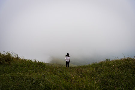 Girl has looking for way to the mountain in the heavy mist and cloudy.の写真素材