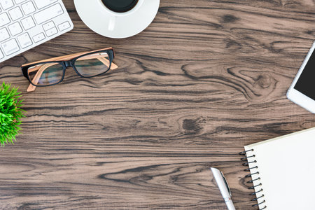 Brown wood office desk table and equipment for working and listening music with white headphone in top view and copy space.の写真素材