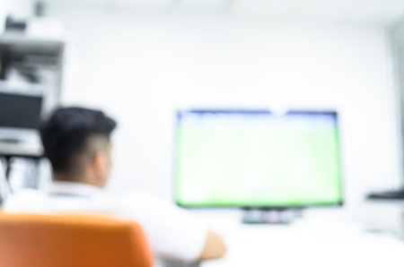 Two man has watching fooball via television on break time and relaxing time in the business office.