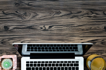 Brown wood office desk table with a book, pen, cactus and phone for working in top view and copy space.の写真素材