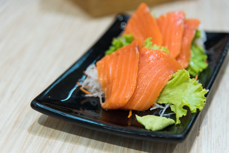 Salmon sashimi on black plate has ready to served.の写真素材