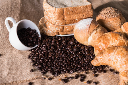Bread and Croissant on the sackcloth with empty coffee cup and coffee beans.の写真素材