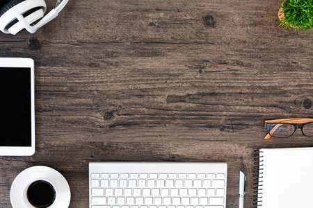 Brown wood office desk table and equipment for working and listening music with white headphone in top view and copy space.の写真素材
