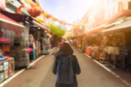Backpack asian girl has traveling and shopping at China Town outdoor market with sunrise in the morning at Singapore.の写真素材