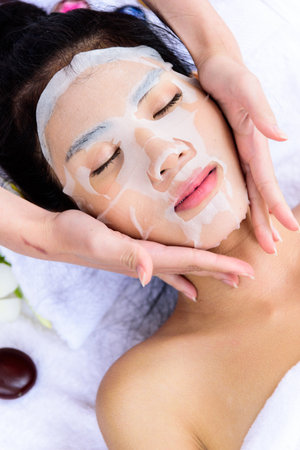 Portrait of beautiful asian people has masking with close up view and close up eyes and having hand massage in spa salon. Beauty, healthy, spa and relaxation concept.の写真素材
