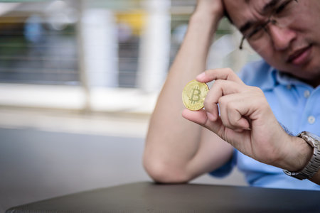 Adisn business man sitting in depression with bit coin money.の写真素材