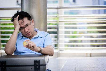 Adisn business man sitting in depression with bit coin money.の写真素材
