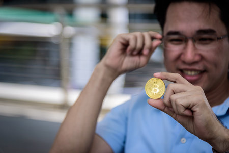 Adisn business man has looking on bit coin money with happy.の写真素材