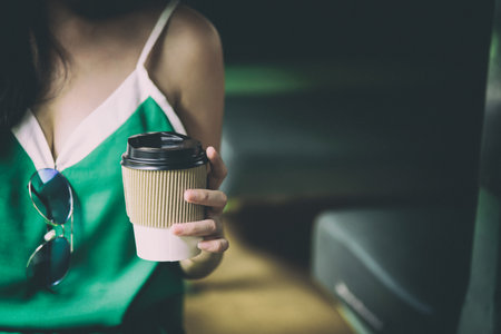 Asian woman traveler has drinking coffee in the train with happiness at Hua Lamphong station at Bangkok, Thailand.の写真素材