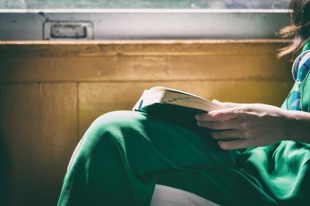 Asian woman traveler has reading a book in the train with happiness at Hua Lamphong station at Bangkok, Thailand.の写真素材