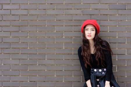 Asian portrait girl has happy and smiling with shopping colorful bags and grey brick wallpaper background.の写真素材