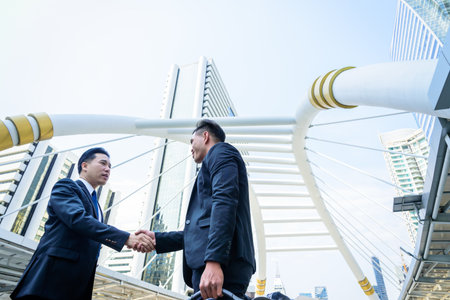 Two asian business have handshake with building and city background.の写真素材