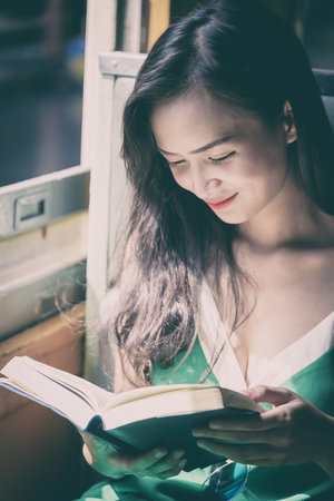 Asian woman traveler has reading a book in the train with happiness at Hua Lamphong station at...