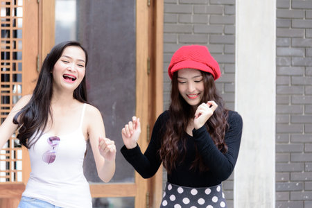 Duo asian portrait girl have dancing with happiness and building background.の写真素材