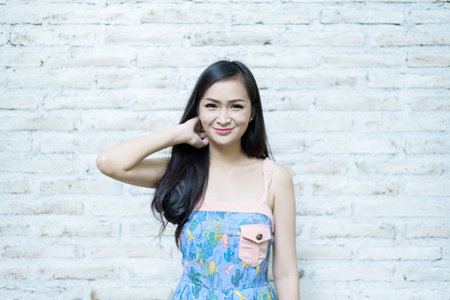 Asian pretty girl has posing hipster concept with brick background at Little Tree Garden cafe, Nakhon Pathom province, Thailand in the morning.の写真素材