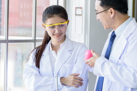 Asian yound student scientist researching  and learning with senior scientist have teaching...