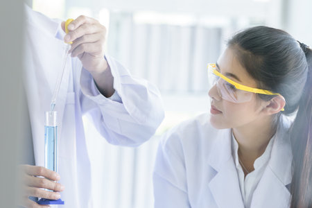 Asian yound student scientist researching  and learning with senior scientist have teaching background in a laboratory.の写真素材