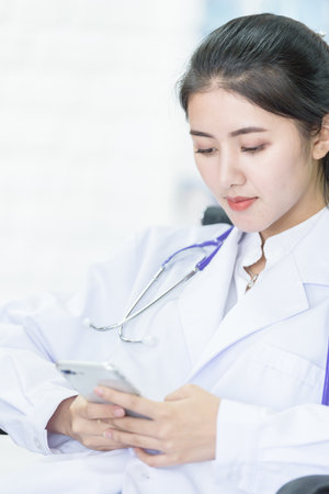 Young asian scientist student has playing phone in break time.の写真素材
