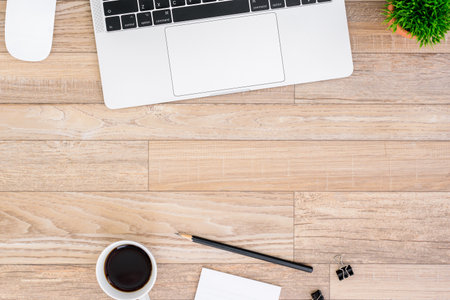 The office desk flat lay view with laptop, mouse, tree, black clip, coffee cup, notebook, pencil on wood texture background.の写真素材