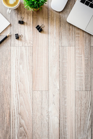 The office desk flat lay view with laptop, mouse, tree, black clip, heart latte coffee cup, notebook, pencil on wood texture background.の写真素材