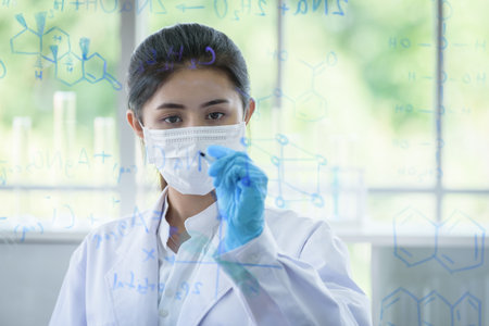 Asian young girl student scientist has writing and researching in laboratory.の写真素材