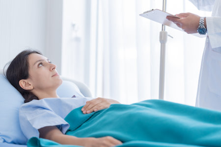 The patient woman has listening the doctor on the bed in the hospital.の写真素材