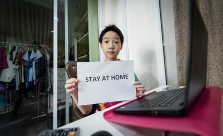 An Asian cute boy stay at home and study online to safe from COVID-19 situation.の写真素材